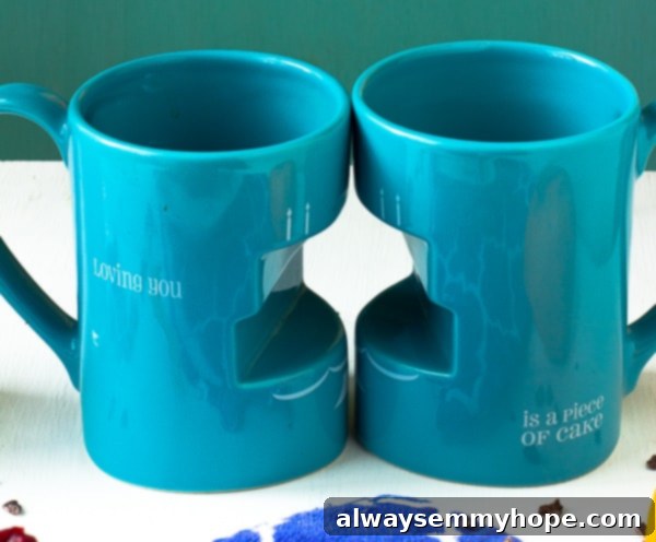 Two charming blue mugs, one with a heart, sit on a rustic wooden table, setting a cozy and romantic breakfast scene.
