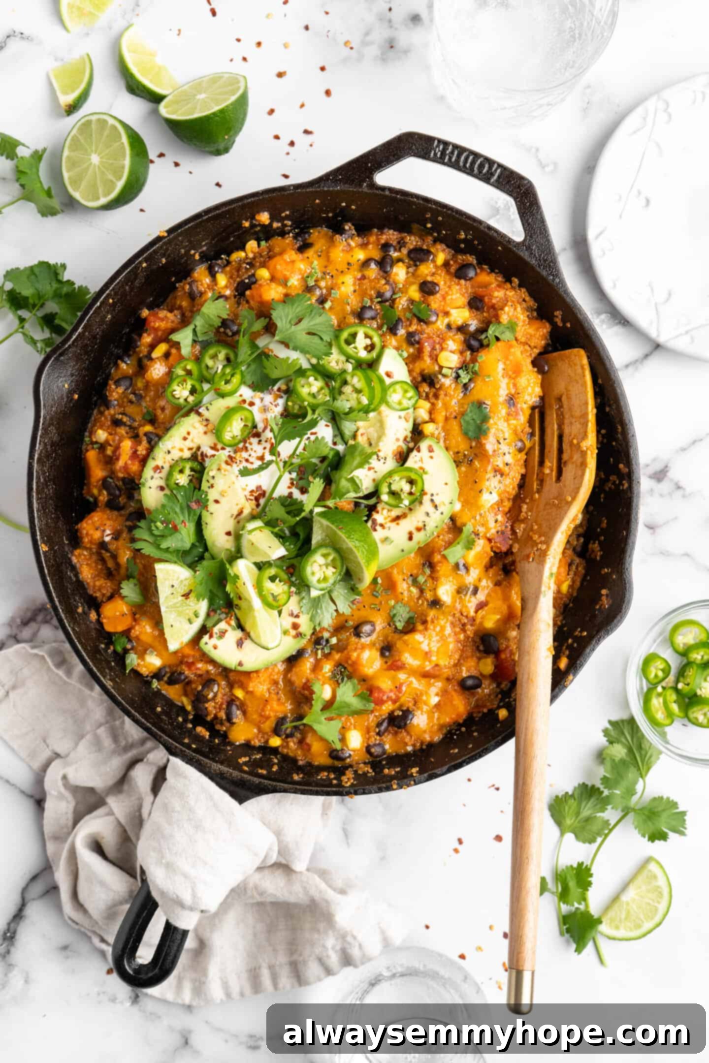 Vibrant vegan enchilada skillet generously garnished with fresh herbs and a serving spoon, showcasing its rich texture and inviting appeal.