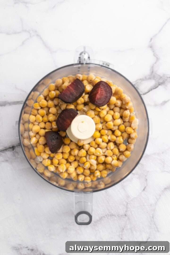 If you like your vegetarian meatballs with beans, veggies and BIG flavor, these chickpea and beet meatballs are for you. Great for meal prep! Overhead view of roasted beets and drained chickpeas ready to be pulsed in a food processor.