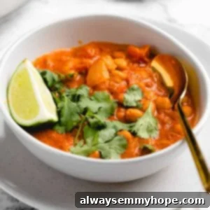 A bowl of creamy vegan coconut chickpea curry garnished with fresh cilantro.