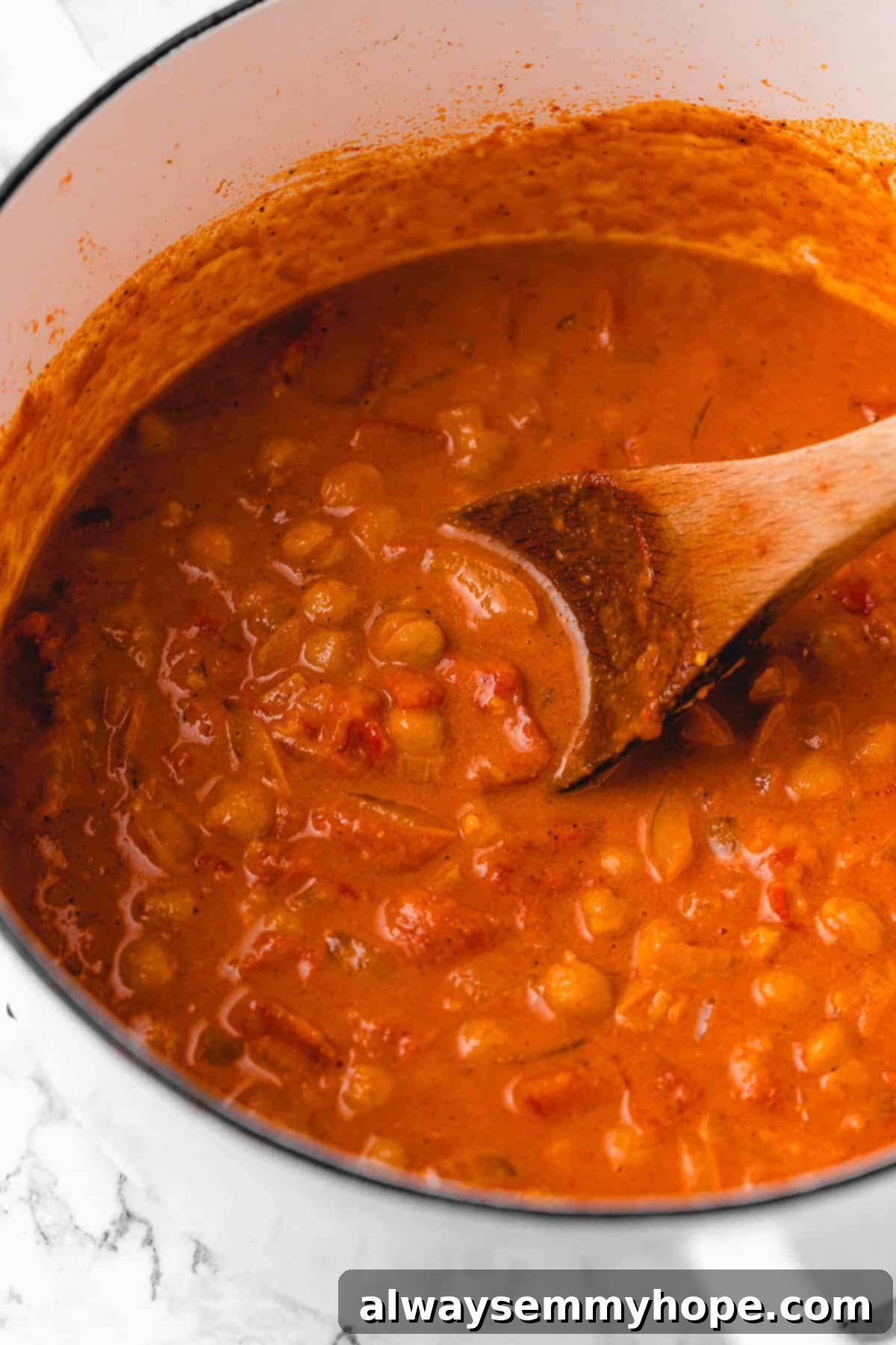 A bowl of creamy vegan coconut chickpea curry ready to be served, garnished with fresh herbs.