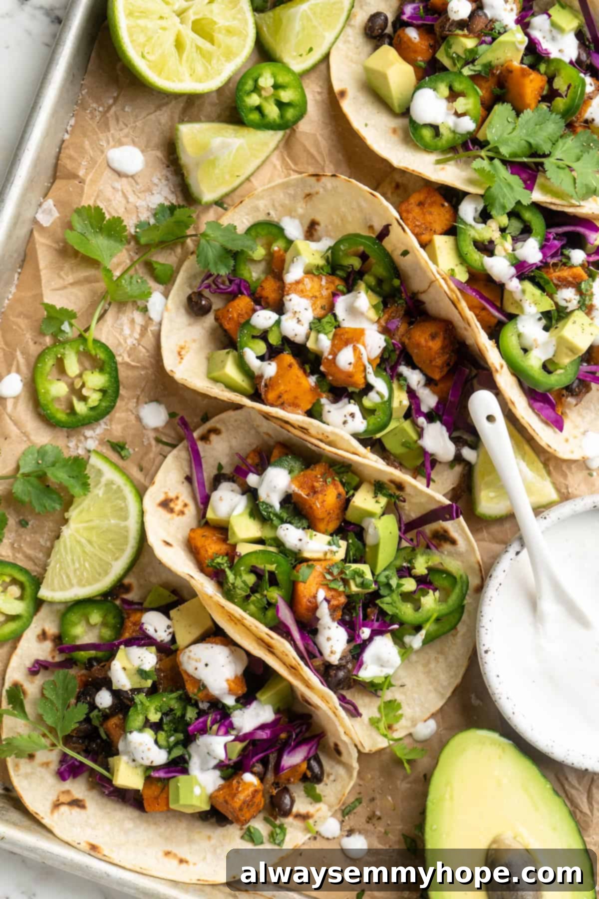 Overhead view of vegan sweet potato and black bean tacos with fresh cilantro and lime wedges, showcasing a vibrant and appealing meal