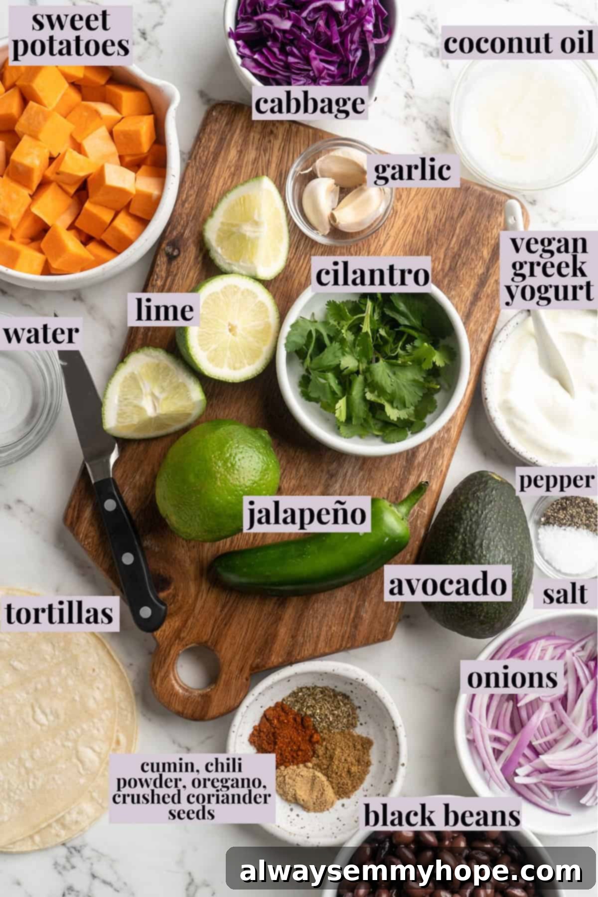 Overhead view of various ingredients laid out on a table for sweet potato and black bean tacos, with individual labels for clarity