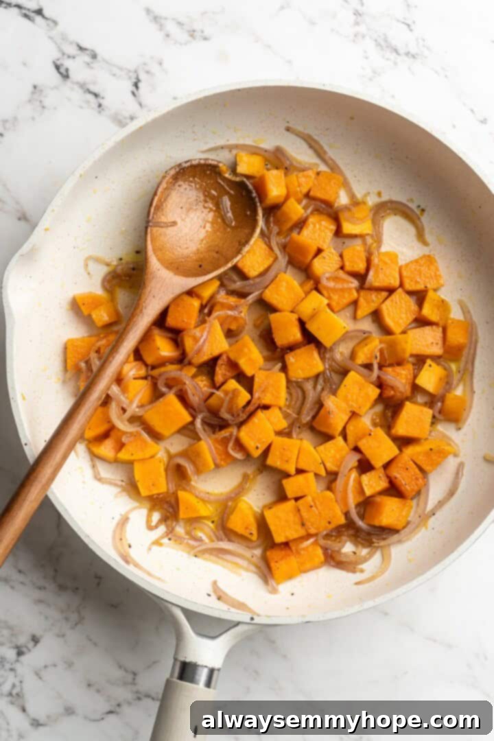 Overhead view of thinly sliced red onions and diced sweet potatoes being added to a hot skillet with coconut oil