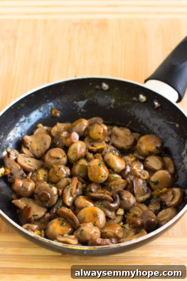 Garlic sautéed mushrooms in a black pan.