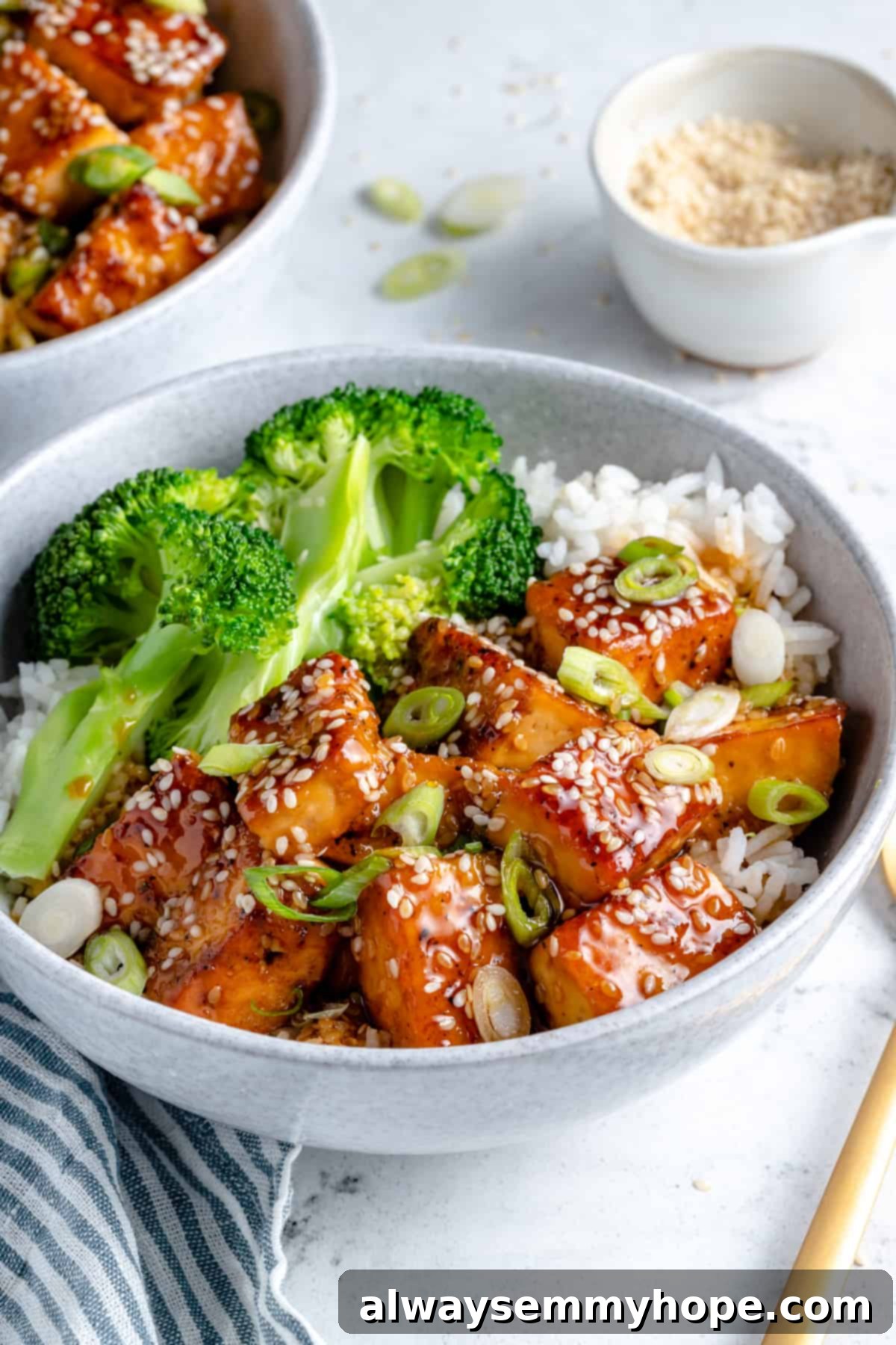 Teriyaki tofu with broccoli and white rice served in a bowl, showcasing the crispy texture and glossy sauce.