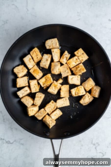 Tofu cubes in a frying pan.
