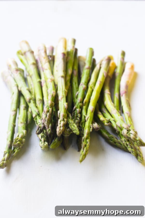 A bunch of raw asparagus on a white table top. 