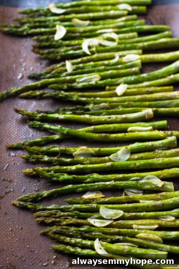 Top down shot of garlic roasted asparagus on a baking tray.