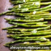Top down shot of garlic roasted asparagus on a baking sheet.