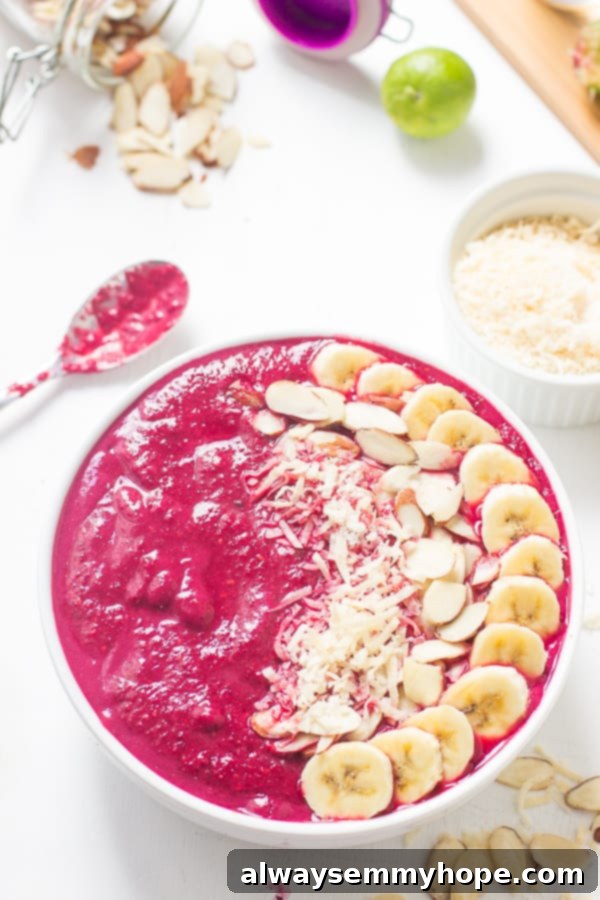 Overhead shot of banana berry beet smoothie bowl with a spoon on the side. 