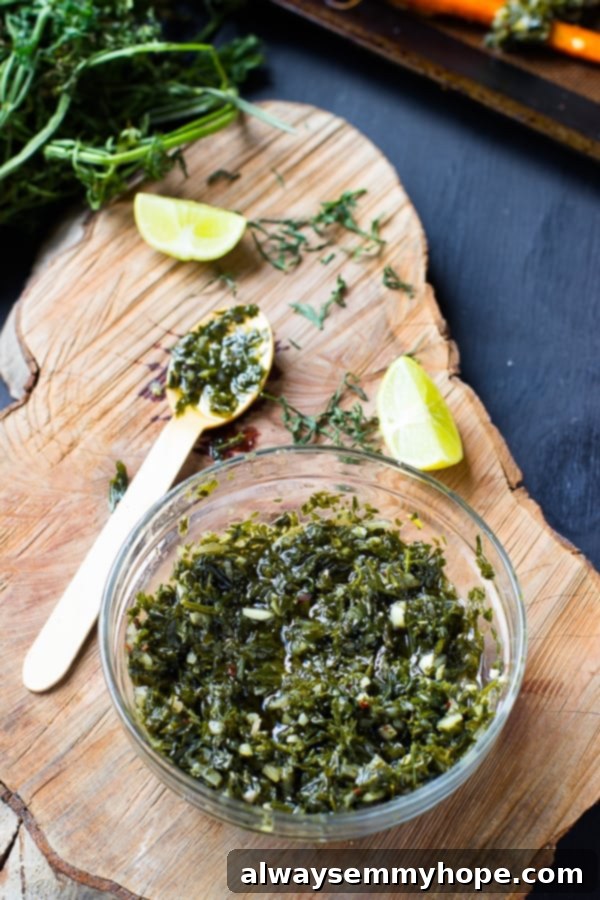 Sweet Maple Carrots with Zesty Greens Chimichurri 4 A bowl of vibrant carrot greens chimichurri with a spoon, ready to be served.