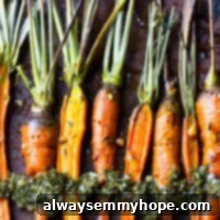 Sweet Maple Carrots with Zesty Greens Chimichurri 7 A row of perfectly maple glazed roasted carrots on a baking sheet.