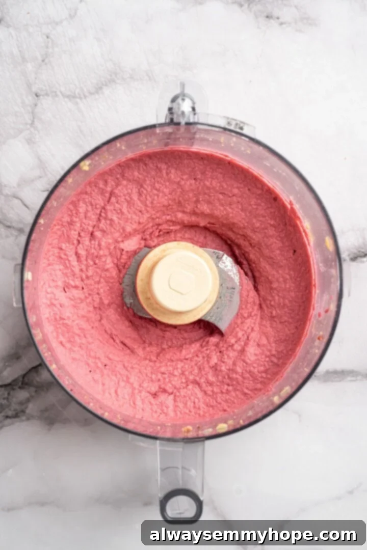 Step 3: Blend all ingredients in the food processor until the beet hummus is perfectly smooth and creamy. Smooth and creamy beet hummus blended to perfection in a food processor, ready to serve.