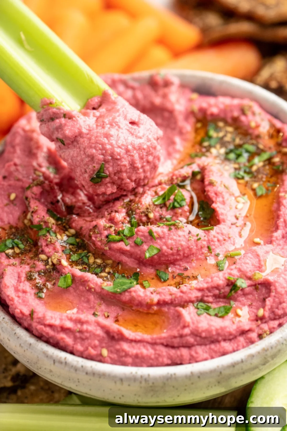 Enjoying a bite of creamy beet hummus with a fresh celery stick, highlighting its irresistible texture. A crisp celery stick dipping into a bowl of creamy, vibrant beet hummus, showcasing its perfect texture.