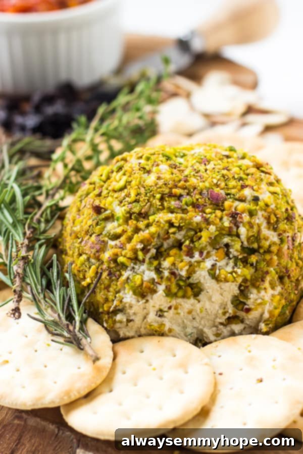 Pistachio Crowned Vegan Cheese Ball 2 Pistachio crusted vegan cheese ball on a wood board with crackers.