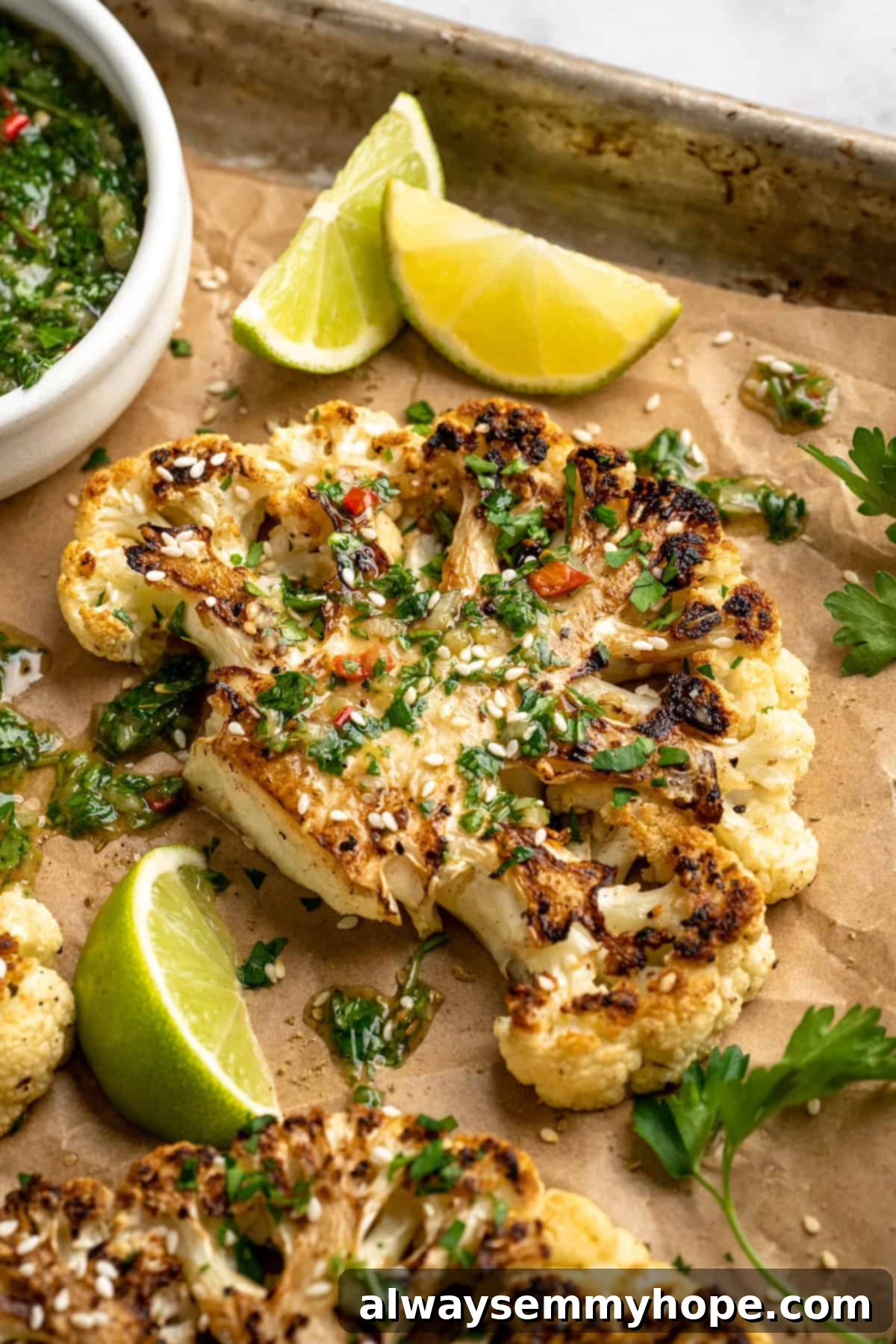These easy roasted cauliflower steaks are tender, crispy on the edges, and incredibly flavourful thanks to the addition of za’atar! Cauliflower steak on sheet pan with chimichurri