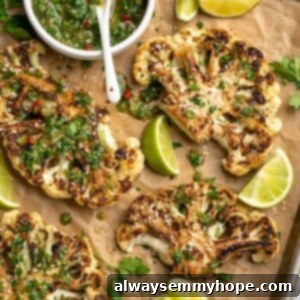 Hearty Roasted Cauliflower Steaks 2 Overhead view of cauliflower steaks on sheet pan with chimichurri in bowl