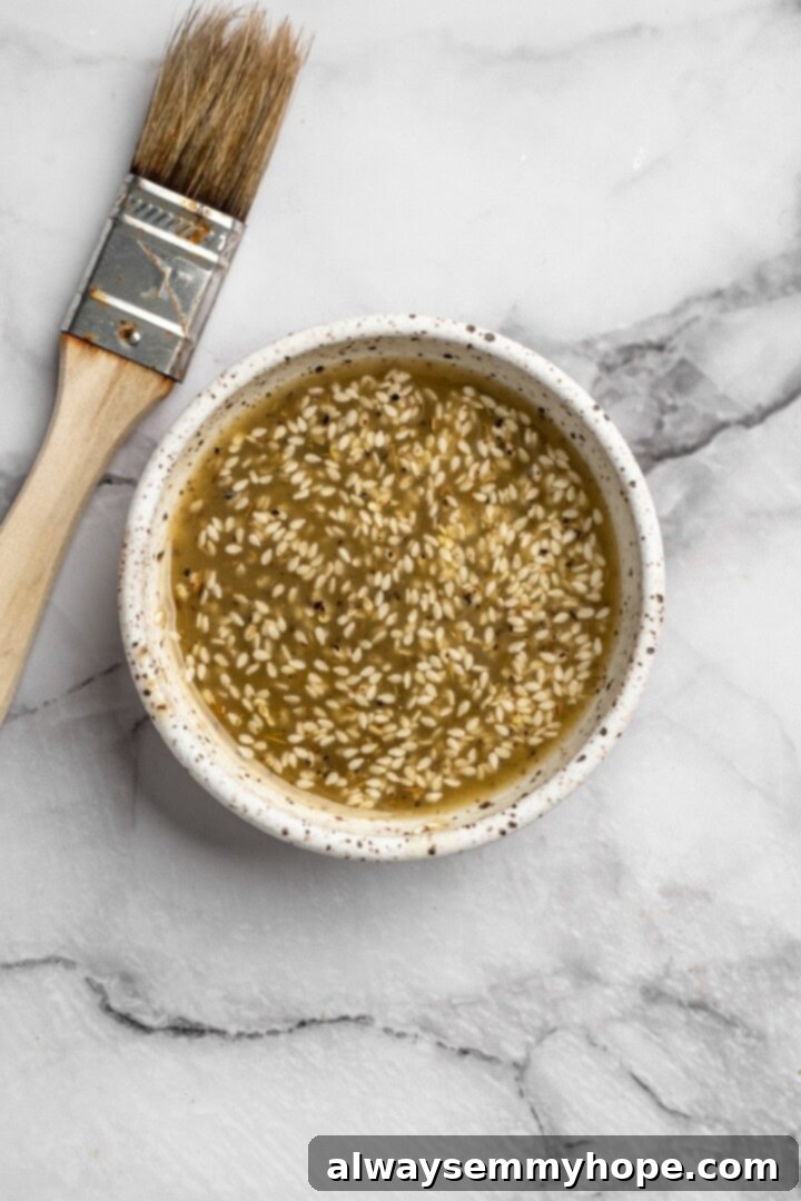 These easy roasted cauliflower steaks are tender, crispy on the edges, and incredibly flavourful thanks to the addition of za’atar! Overhead view of seasoning mixture for in bowl with brush