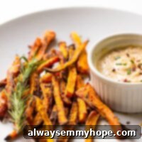 Baked carrot fries on a white plate with tahini dip on the side.
