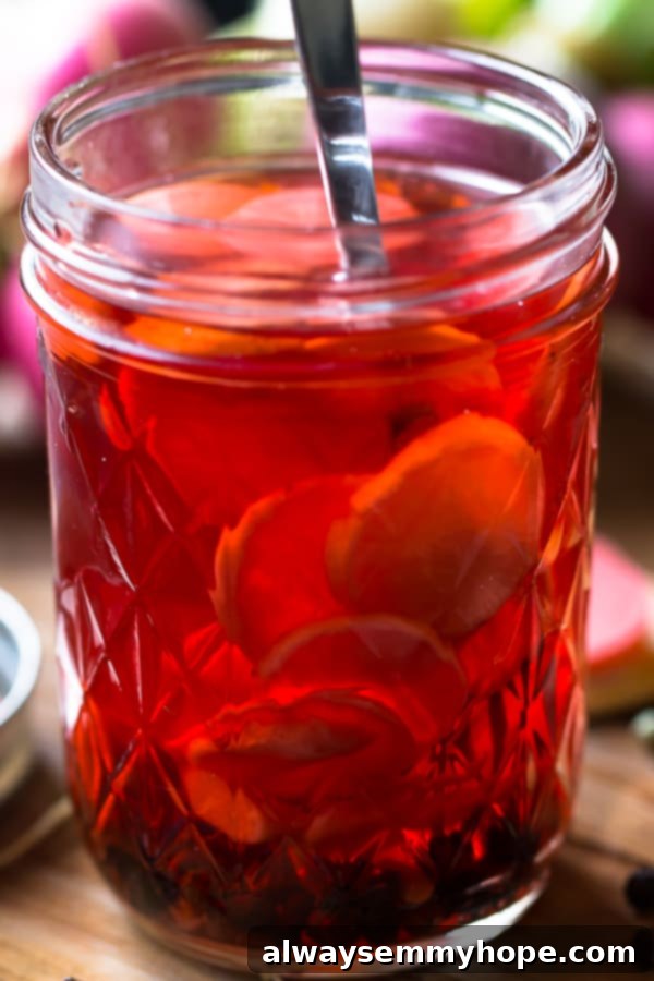 Side on shot of quick pickled radishes in a glass. Close-up side view of quick pickled radishes in a glass jar, showcasing their vibrant color.