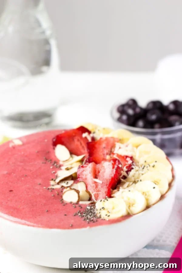 Strawberry lime coconut smoothie bowl with fresh fruit on top. 