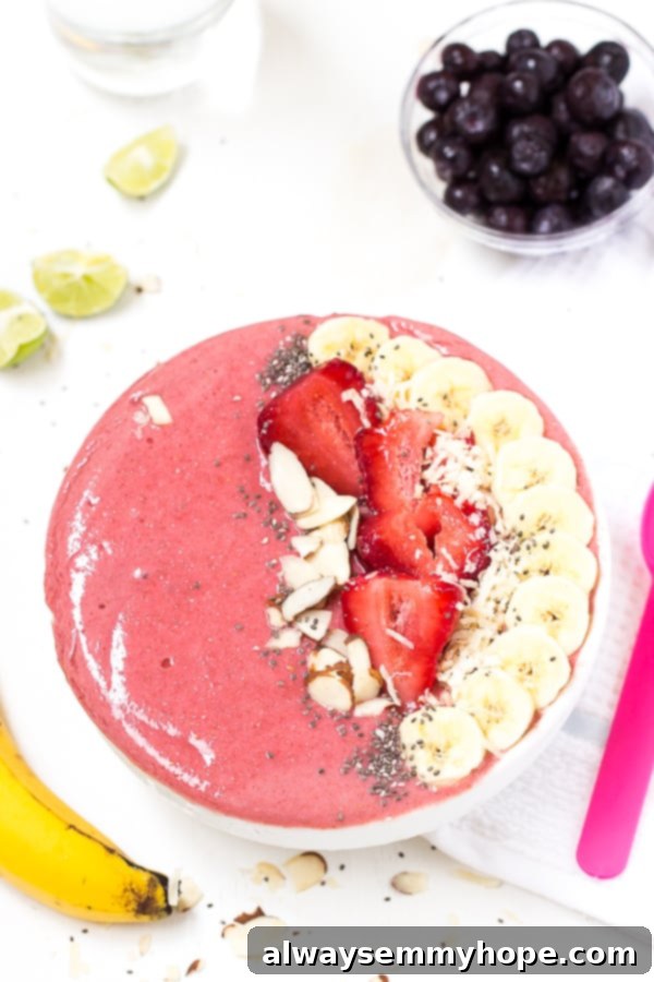 Top down shot of strawberry lime coconut smoothie bowl with fresh fruit.