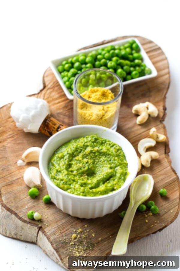 Cashew pea pesto in a white ramekin with ingredients around it. 
