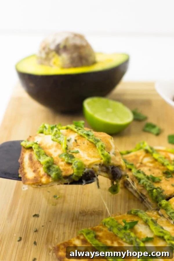 Mexican quesadillas with avocado cilantro cream sauce on a wood board.