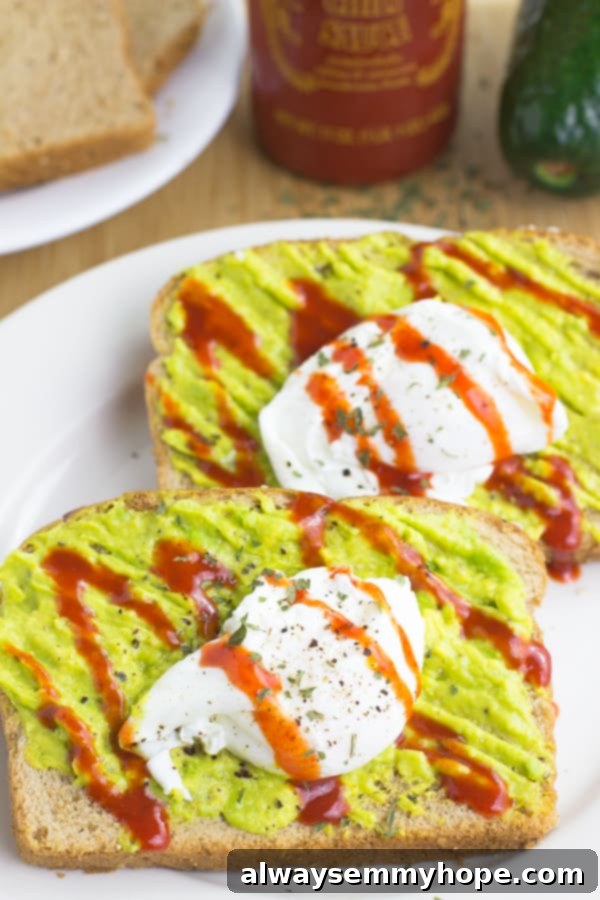 Two sriracha poached eggs and avocado smash toast on a white plate.