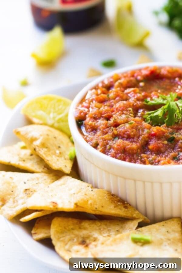 This easy restaurant-style blender salsa is made with fresh tomatoes for lots of bright flavour. Add your fave tortilla chips and dig in! Bowl of blender salsa on plate with tortilla chips