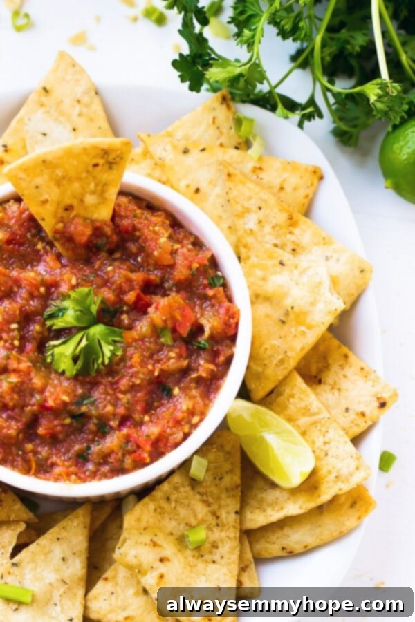 This easy restaurant-style blender salsa is made with fresh tomatoes for lots of bright flavour. Add your fave tortilla chips and dig in! Plate of chips with restaurant-style salsa