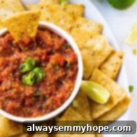 Your Favorite Restaurant Salsa Made in a Blender 3 Top down shot of salsa in a white ramekin with chips around it.