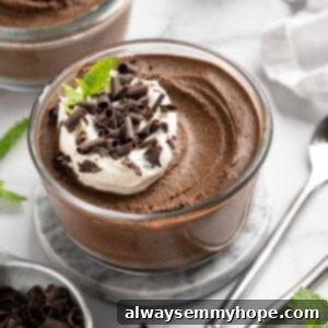 Decadent 10-Minute Chocolate Avocado Pudding 2 Bowl of chocolate avocado pudding with coconut whipped cream and chocolate shavings on top.