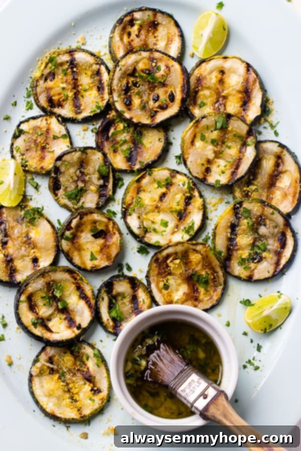 Overhead view of a generous platter of golden-brown lemon garlic grilled zucchini slices, ready to be served.