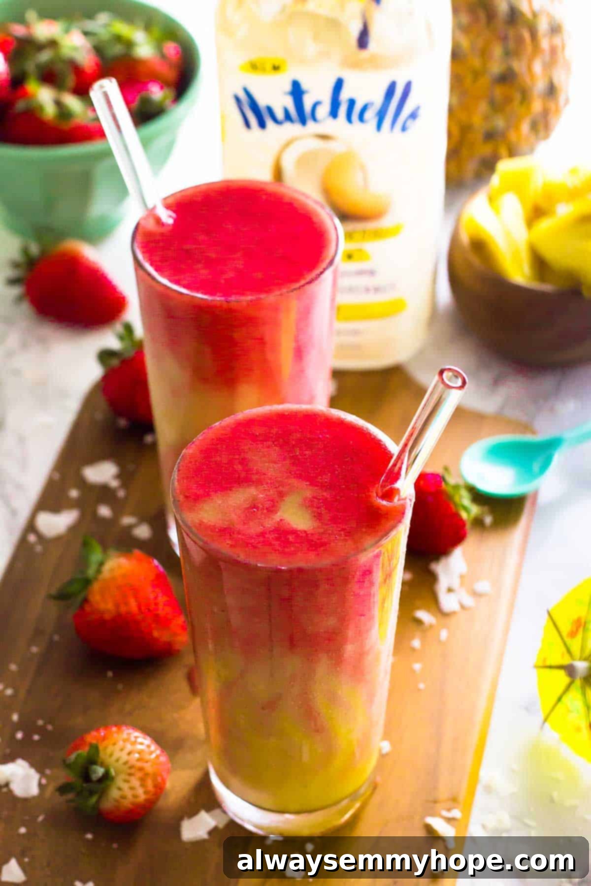 Strawberry Pineapple Coconut Lava Flow Smoothie Two vibrant Strawberry Pineapple Coconut Lava Flow Smoothies in tall glasses, garnished with fresh strawberries and pineapple wedges, served on a rustic wooden board, inviting a taste of tropical bliss.