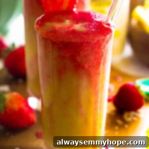 Strawberry Pina Colada Smoothie 2 Close-up of a refreshing Strawberry Pineapple Coconut Lava Flow Smoothie, showcasing vibrant layers in a glass.