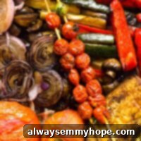 Overhead view of balsamic grilled vegetables, including cherry tomatoes on skewers, onions, zucchini, mushrooms, and eggplant