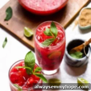 Two watermelon mojitos with pitcher on wood board