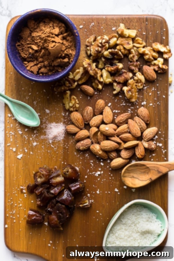 Five core ingredients laid out on a wooden cutting board: whole walnuts, raw almonds, pitted Medjool dates, cocoa powder, and shredded coconut flakes, along with a pinch of salt.