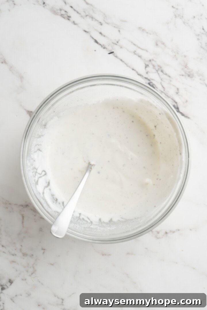 Preparing the Vegan Lime Crema. Overhead view of homemade vegan lime crema in a small bowl with a spoon.