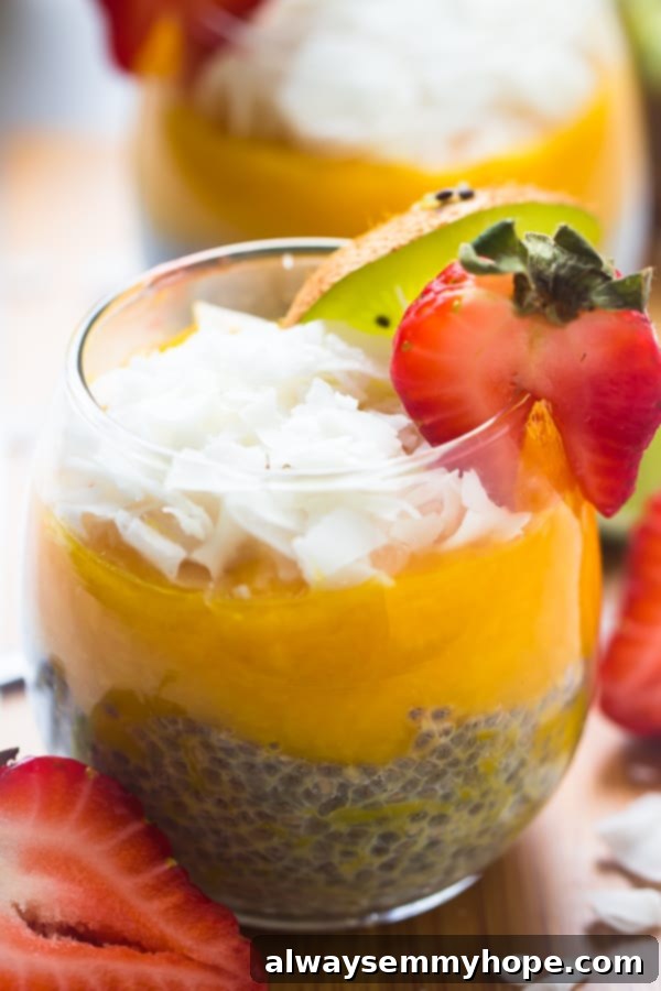 Close up of mango coconut chia seed pudding in a wine glass, with another pudding in the background.