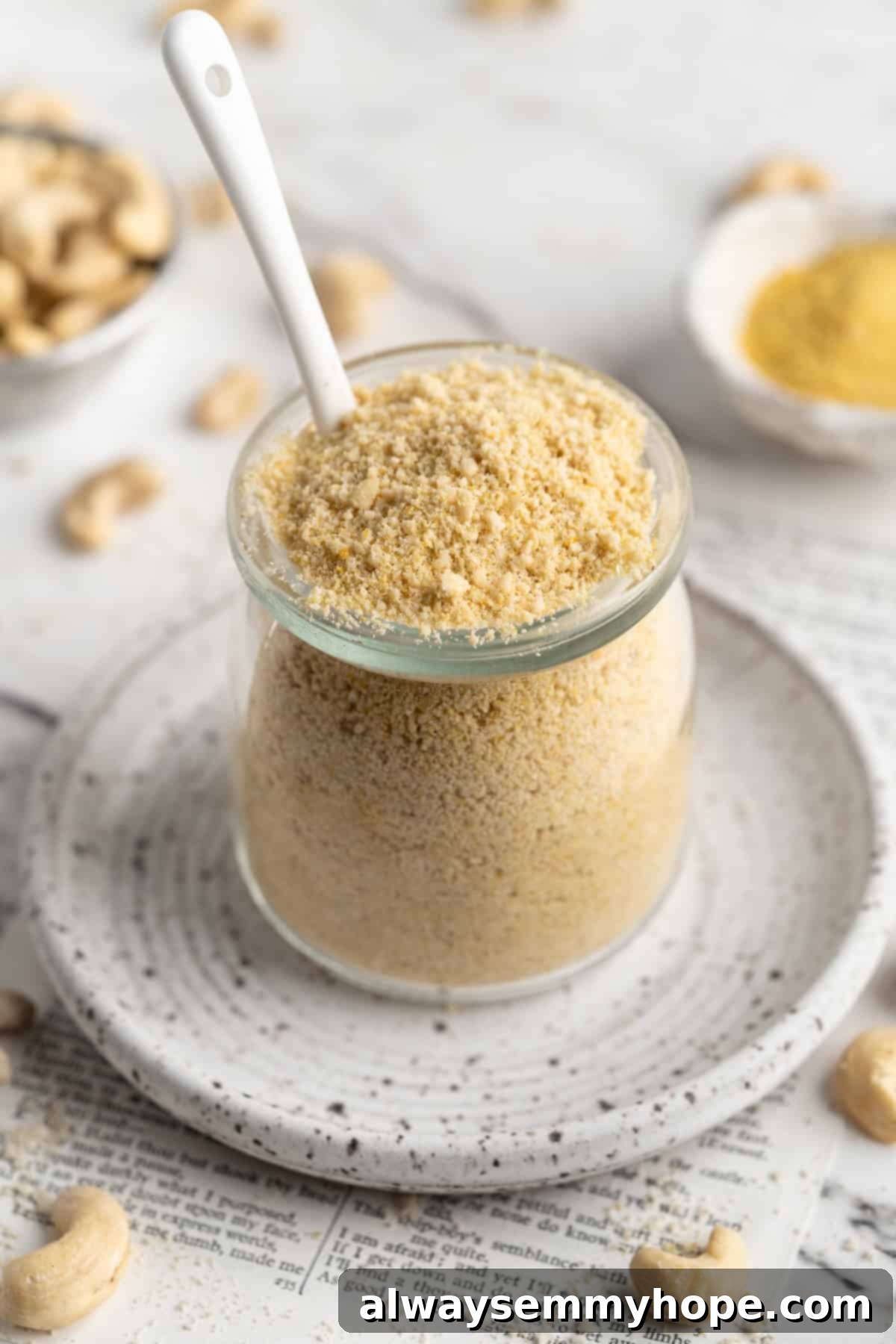 Jar of homemade vegan Parmesan cheese with spoon, ready to be served over pasta or salad.