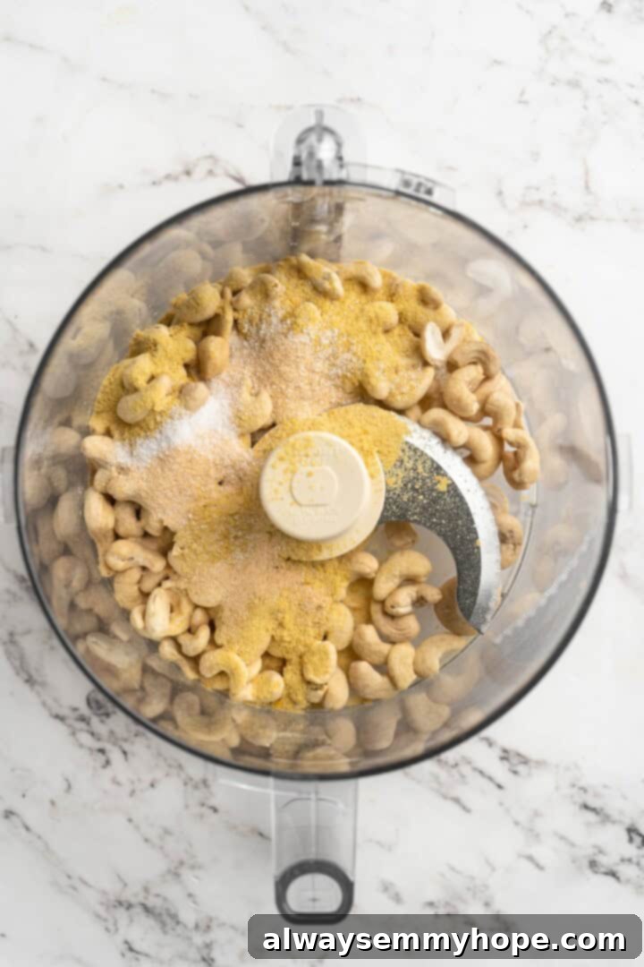 Overhead view of all five ingredients for vegan Parmesan cheese placed in a food processor bowl before blending.