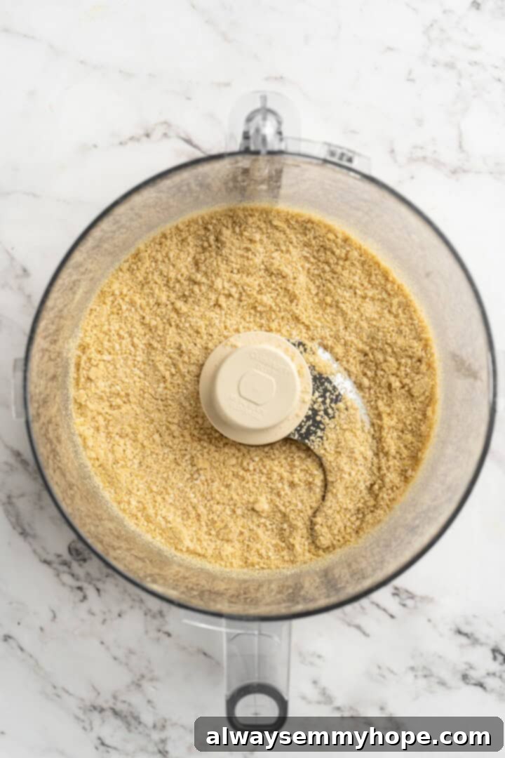 Overhead view of the vegan Parmesan cheese mixture after being pulsed in a food processor, showing a coarse, grated texture.