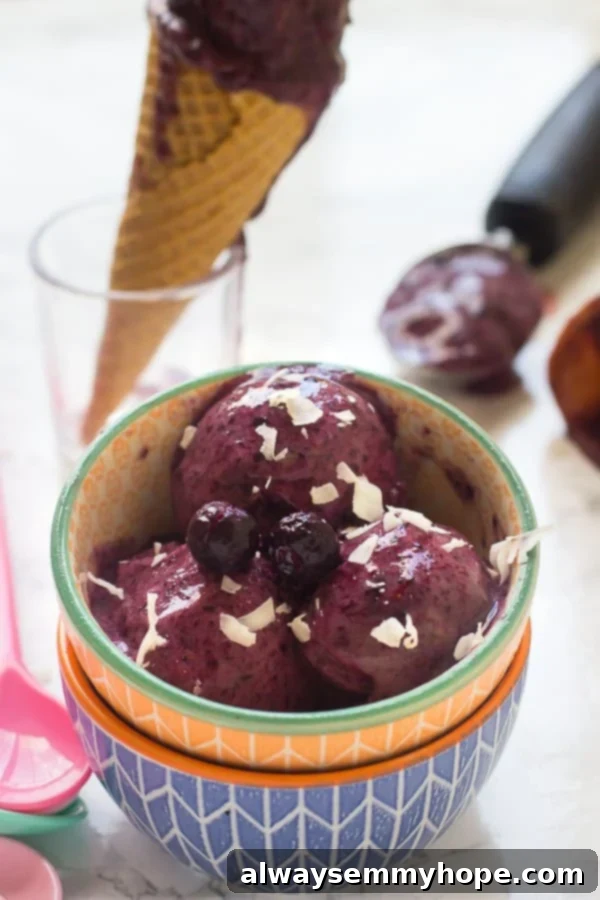 Close-up of smooth, vibrant purple vegan blueberry ice cream in a colorful bowl, showing its creamy texture.