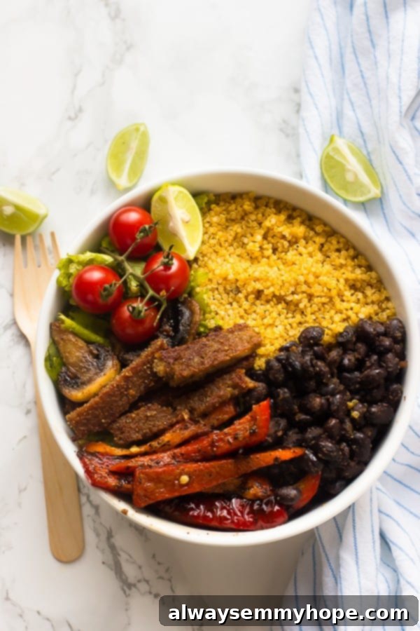 Vegan Fajita Bowls - 10-Minute Prep, High Protein 3 A top-down shot of a beautifully arranged vegan fajita bowl on a pristine white tabletop, showcasing all its colorful and fresh ingredients.