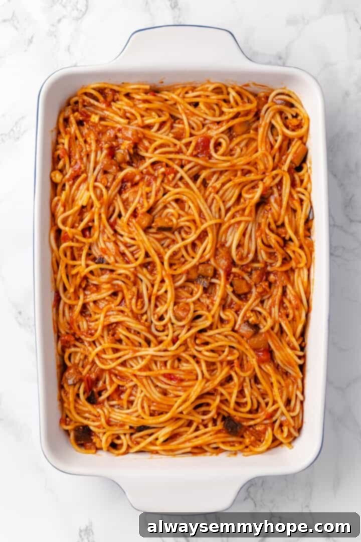 Spaghetti and sauce in dish before adding cheese