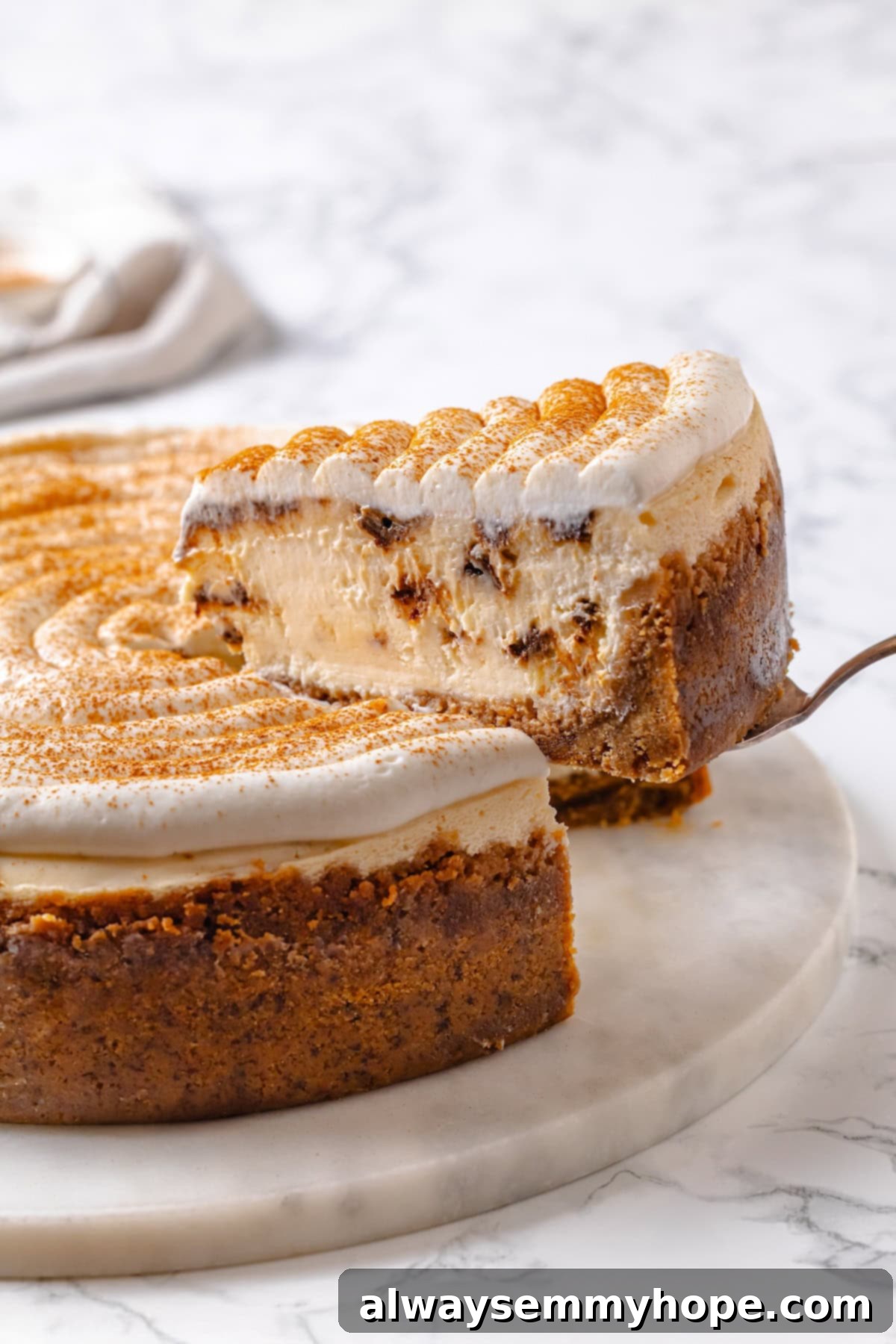 Lifting slice of cinnamon roll cheesecake from marble platter