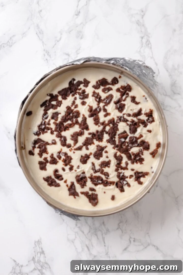 Unbaked cinnamon roll cheesecake in springform pan